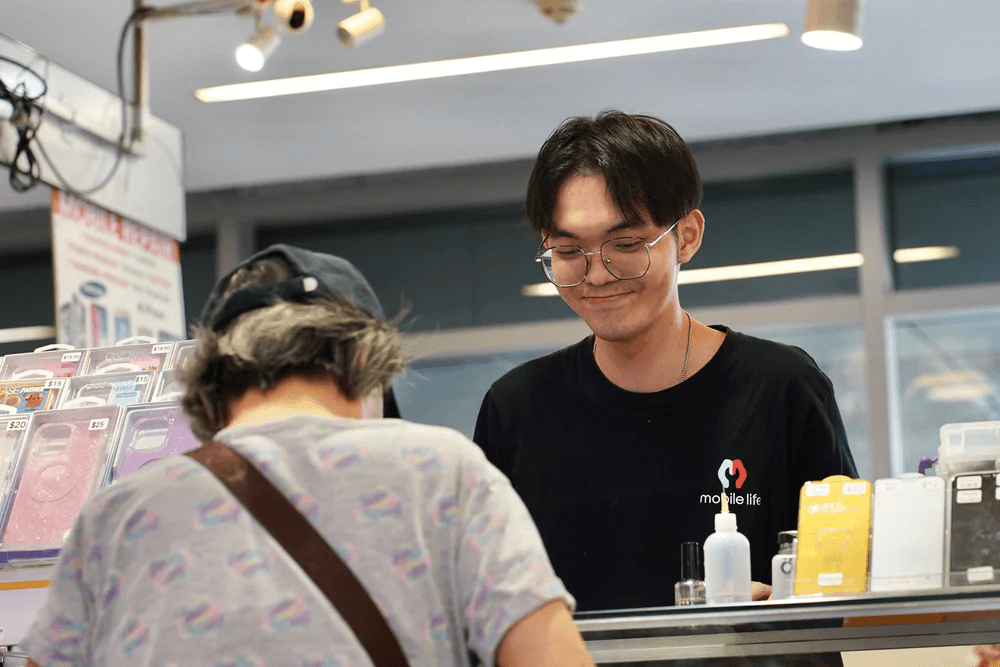 A Mobile Life technician helping a customer at the service counter