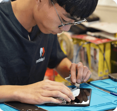 A Mobile Life technician carefully repairing a smartphone